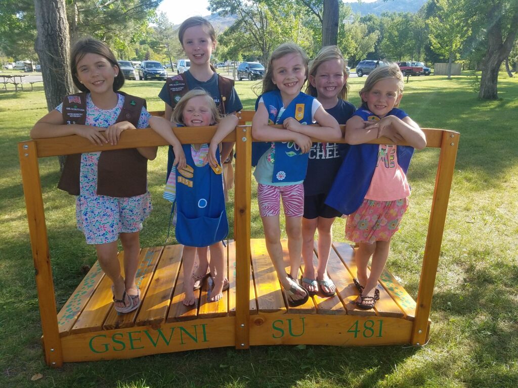 A group of Girl Scouts in their uniforms outdoors. 